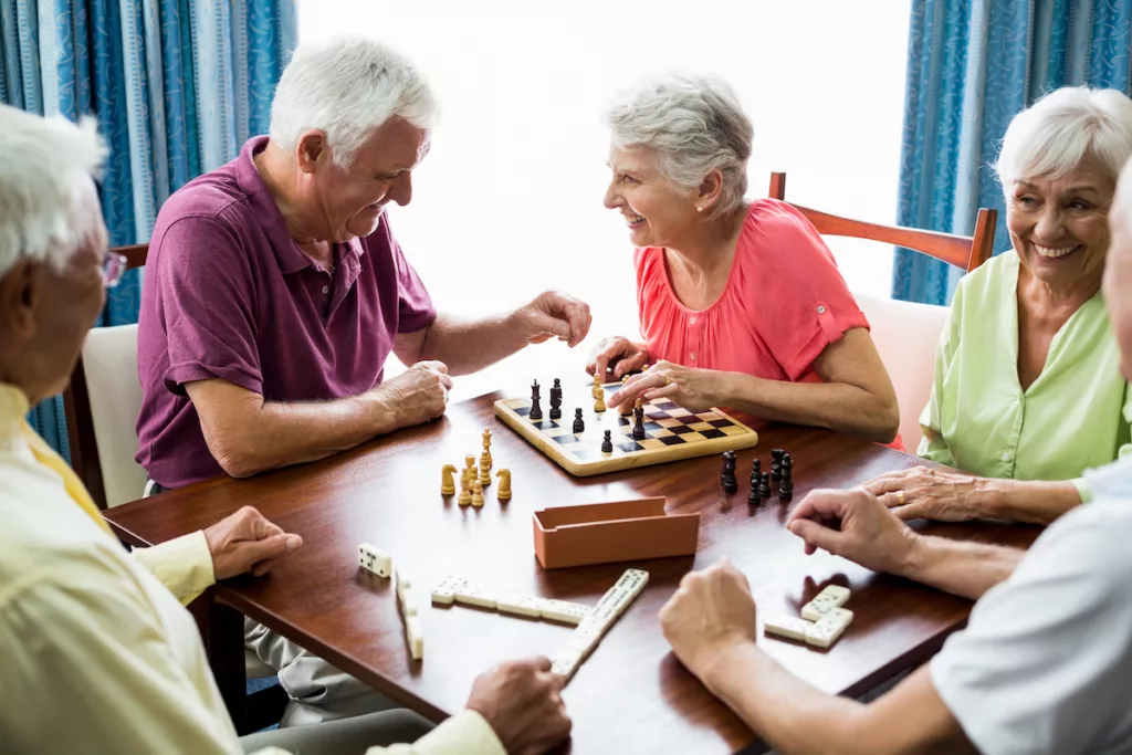 Happy Seniors Playing Chess and Dominos_Senior Living Ormond Beach
