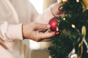 Senior Woman Hanging Ornaments on Christmas Tree_Aden Senior Living