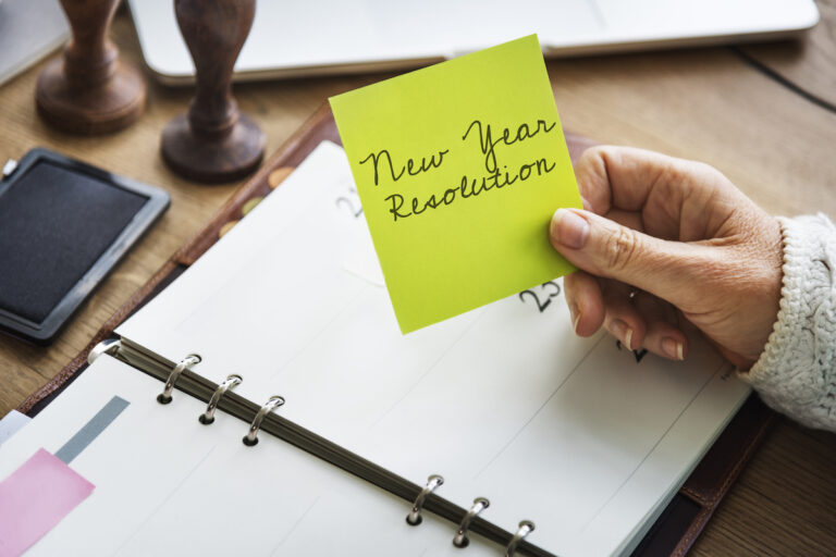 Senior Woman Holding New Year's Resolutions Sticky Note_Aden Senior Living