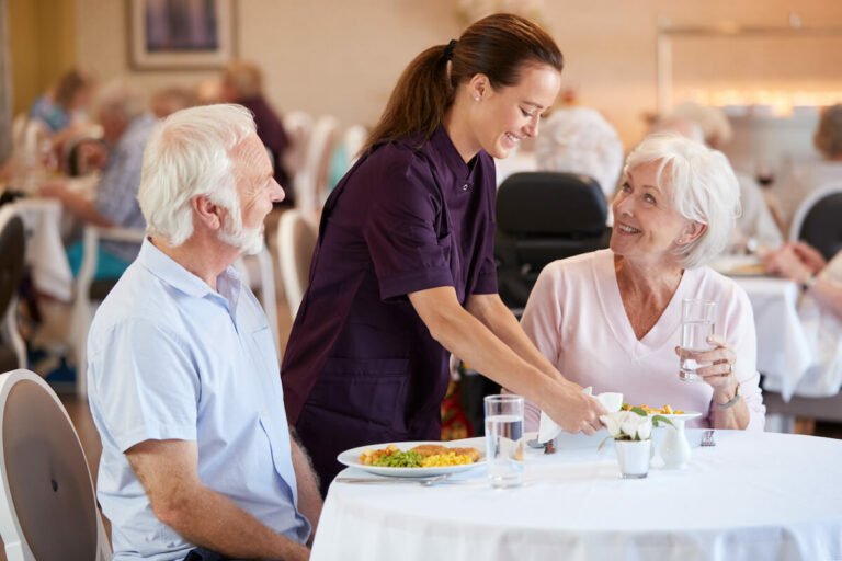 Picture of two seniors getting Person-Centered Care at a Senior Living's dining room.